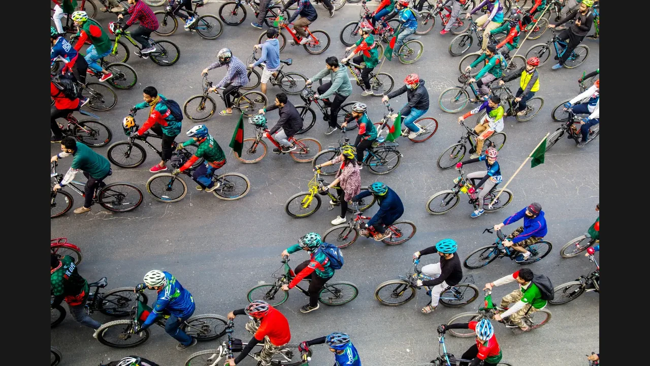 Aerial photograph of a large group of cyclists riding together on a city road